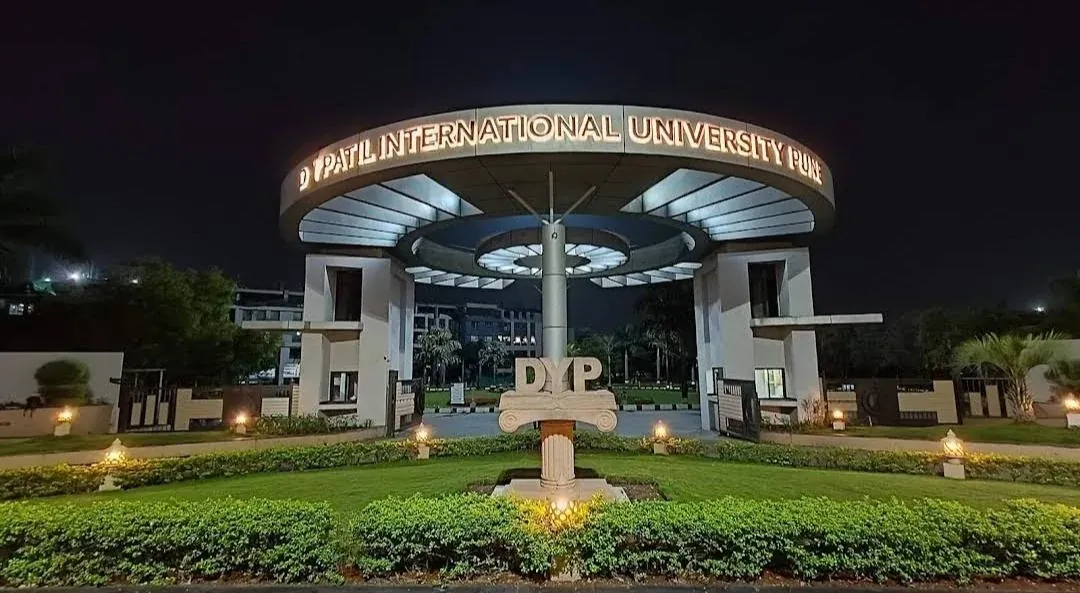 DY Patil International University Pune main entrance gate at night — illuminated archway with university signage and DYP monument · 33 LPA highest, 7.5 LPA average · 250+ companies, 1000+ placements