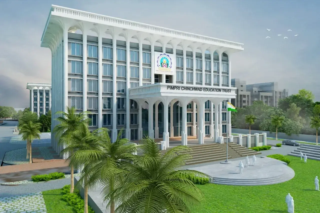 Pimpri Chinchwad Education Trust main academic block at PCU campus &mdash; classical white arched fa&ccedil;ade with central pillared entrance, PCET banner across the front, Indian flag flying, palm trees and landscaped lawn in the foreground &middot; 30-acre Sate Maval Pune campus